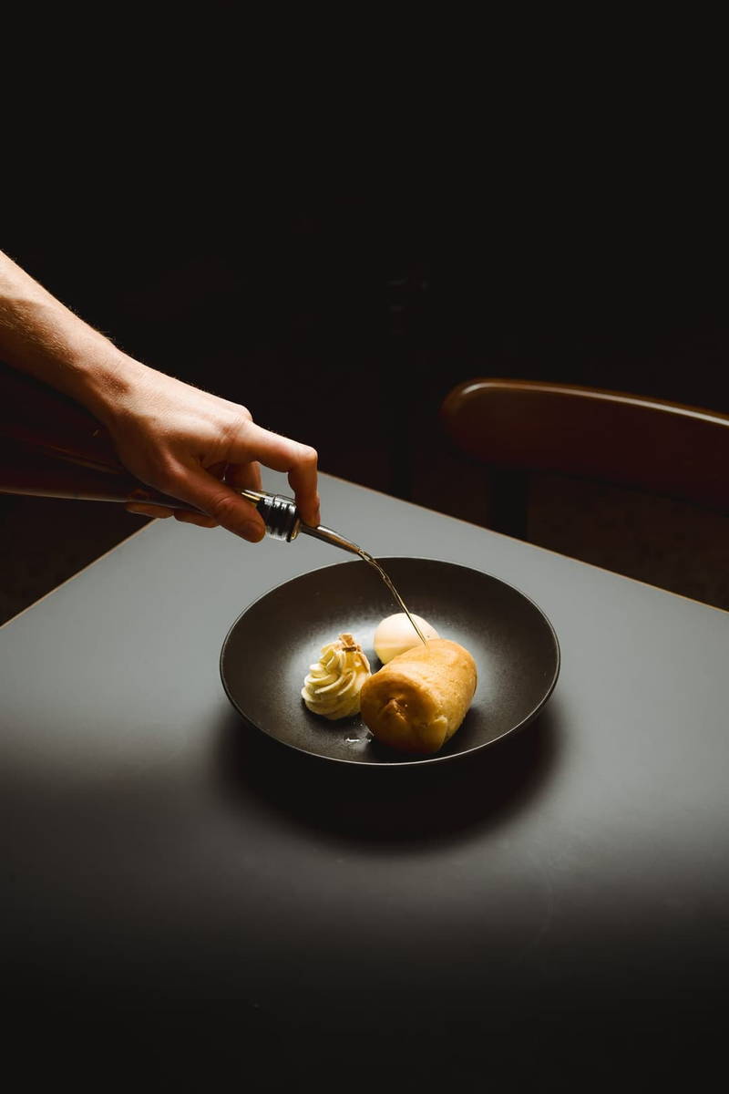 A chef finishing a dish under low light.